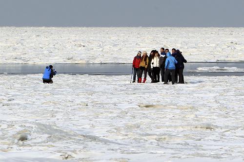 1月9日,在辽宁大连夏家河子海滨浴场内,游人在海冰上游玩。新华社发(王华 摄)
