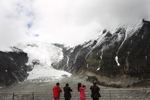 4月26日,游客在四川海螺沟景区观赏冰川雪瀑。新华社发(张晓理 摄)