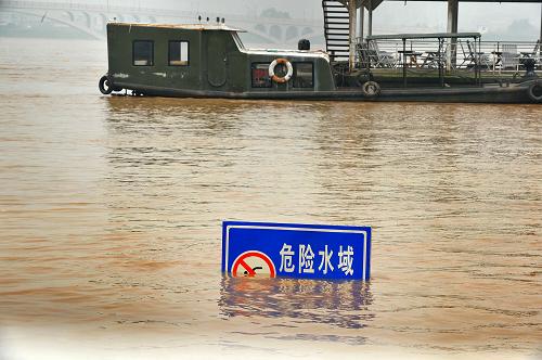 这是长沙湘江边一处被洪水淹没的亲水平台,露出水面的是原本高出水面许多的警示牌(6月13日摄)。新华社记者 龙弘涛 摄