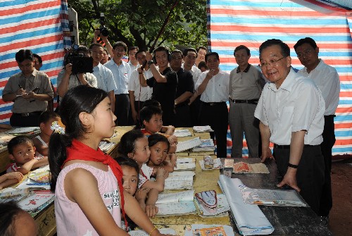 6月20日至22日,中共中央政治局常委、国务院总理温家宝到受汶川大地震波及的陕西、甘肃灾区检查指导抗震救灾工作,看望干部群众。这是6月20日,温家宝在陕西省略阳县权力村帐篷小学内倾听小学生宋雪谈震后感受。 新华社记者 黄敬文 摄