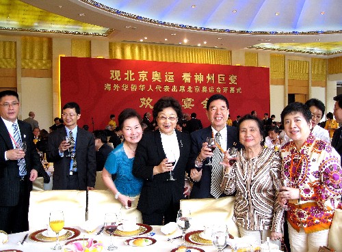 8月8日,国务院侨办主任、中国海外交流协会常务副会长李海峰(中)在宴会上与海外华侨华人代表合影留念。 新华社记者 吕淑梅 摄