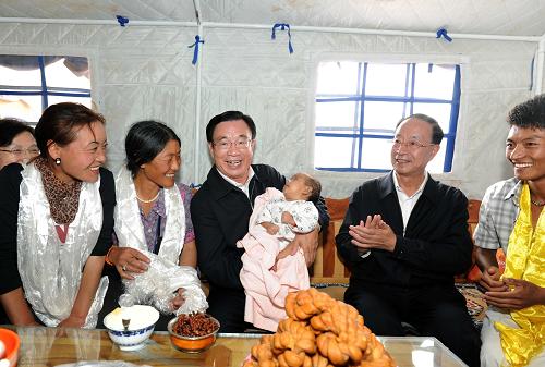 8月17日,中共中央政治局常委、中央纪委书记贺国强在青海省玉树藏族自治州出席玉树地震灾后安置、恢复重建暨监督检查工作汇报会并发表讲话。会前,贺国强深入玉树灾区,看望慰问灾区各族干部群众和奋战在恢复重建一线的广大建设者,实地考察受灾群众安置、灾后恢复重建及监督检查工作情况。这是在结古镇扎西大同村,贺国强走进村民卓玛永吉(左二)家中,抱着卓玛永吉两个月大的小孙女,与一家人亲切攀谈。新华社记者 李涛 摄