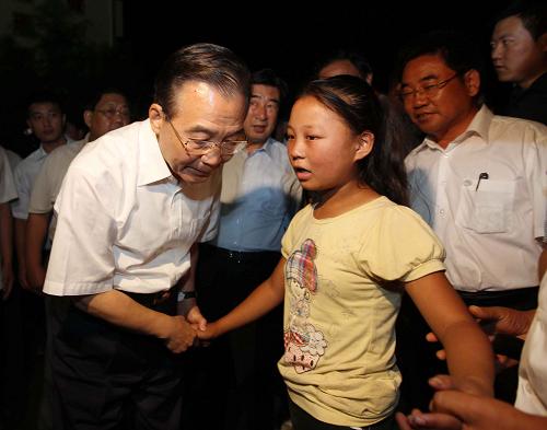 8月21日至22日,中共中央政治局常委、国务院总理温家宝再次来到舟曲灾区,看望受灾群众,慰问坚守救灾一线的部队官兵,实地指导抢险救灾和恢复重建工作。这是8月21日晚,温家宝在舟曲县第一中学的受灾群众安置点看望受灾群众时,安慰一名小姑娘。 新华社记者 刘卫兵 摄