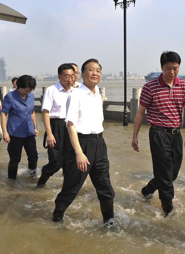 中共中央政治局常委、国务院总理温家宝近日在湖北考察防汛抗洪工作。这是7月23日,汉口龙王庙险段防洪墙外的观江平台已被江水淹没。温家宝趟着一尺深的江水察看汛情。新华社记者 黄敬文 摄