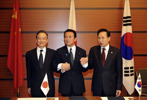 12月13日,中国国务院总理温家宝、日本首相麻生太郎、韩国总统李明博在日本福冈正式签署《三国伙伴关系联合声明》。这是三国领导人签字后握手。新华社记者 马占成 摄