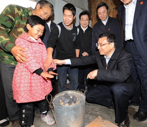 近日,中共中央政治局常委、国务院副总理李克强深入四川地震灾区的乡村农户、板房医院、企业车间和建设工地,看望慰问灾区群众,实地考察灾后恢复重建。这是10月26日,李克强在映秀镇渔子溪村民李连华(左后老者 )新建起来的永久性住房里了解他们一家的居住和生活情况。新华社记者 马占成 摄