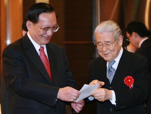 2月21日,在日本首都东京,日中友协会长平山郁夫(右)向中国国务委员唐家璇展示两人多年前的老照片。唐家璇20日下午抵达东京,开始对日本进行访问。 新华社记者任正来摄