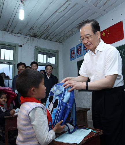“六一”国际儿童节前夕,中共中央政治局常委、国务院总理温家宝在湖南湘西武陵山区调研扶贫开发工作时,专程到当地农村小学,看望慰问师生特别是在校的留守儿童,祝他们节日快乐。 5月25日,在古丈县默戎镇毛坪村教学点——毛坪小学,温家宝为孩子们带来了新书包。当工作人员递上一个粉红色书包让总理给8岁的龙英俊时,他不要:“我是男生,不要这个颜色。”这情景把大家都逗乐了。“哦,忘了你是个男子汉!”温家宝赶紧让人换了一个蓝色书包。这个富有个性的“小男子汉”接在手中,站起来给总理敬了个礼。新华社记者 庞兴雷 摄