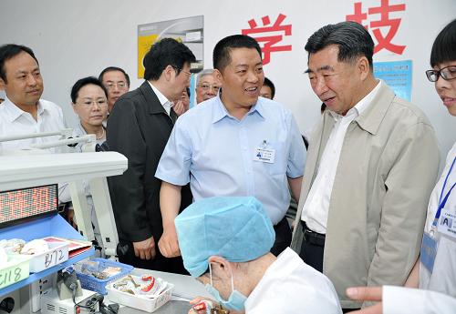 5月15日,中共中央政治局委员、国务院副总理、国务院残疾人工作委员会主任回良玉专程来到北京市的残疾人集中就业单位,看望慰问在这里工作的残疾人职工。这是回良玉在北京赢冠义齿加工有限责任公司生产车间内参观。新华社记者 王晔 摄