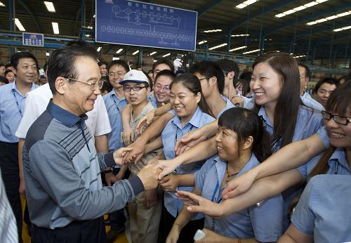 10月13日至14日,中共中央政治局常委、国务院总理温家宝在出席第110届广交会开幕式期间,就经济形势尤其是当前外贸企业情况进行调研。这是10月14日,温家宝在广州大阳摩托车有限公司亲切看望企业职工。新华社记者 李学仁 摄