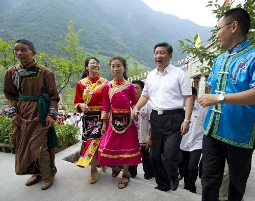 这是习近平在北川县擂鼓镇吉娜羌寨,在村民王成兵一家人的簇拥下,来到他家看望并了解灾后重建以及搬进新居后发展旅游的情况。 新华社记者 李学仁摄