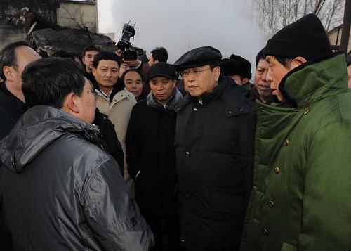11月21日,根据胡锦涛总书记、温家宝总理的重要指示,中共中央政治局委员、国务院副总理张德江赶赴黑龙江龙煤集团鹤岗分公司新兴煤矿事故现场,指导救援工作。这是张德江在事故现场听取救援人员情况汇报。新华社记者 李涛 摄