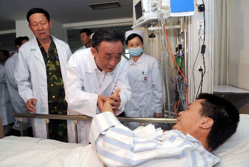 5月26日,中共中央政治局常委、全国人大常委会委员长吴邦国专程赴四川地震灾区,慰问干部群众,看望救援人员,指导抗震救灾工作。这是吴邦国委员长在成都军区总医院看望在废墟中掩埋了108个小时被救出的55岁的李克诚。 新华社记者 饶爱民 摄