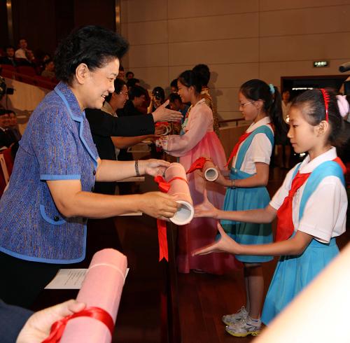 9月1日,2009年“中小学弘扬和培育民族精神月”启动仪式在北京举行。中共中央政治局委员、国务委员刘延东出席启动仪式并讲话。这是刘延东向中小学生代表赠送《新中国60年教育挂图》。新华社记者高学余摄