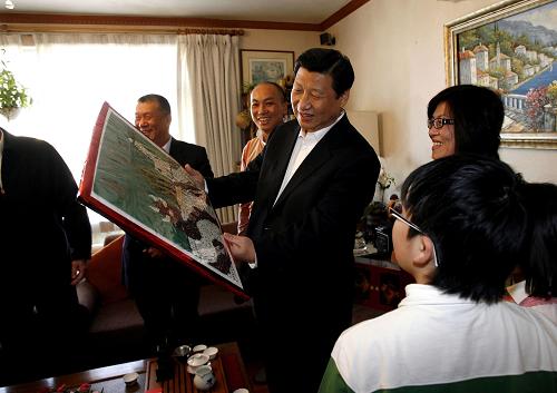 1月10日,国家副主席习近平来到澳门普通市民胡祖杰家中探访,了解他们生活、工作情况。这是胡祖杰一家将亲手制作的五谷杂粮画作回赠习近平。 新华社记者刘莲芬摄