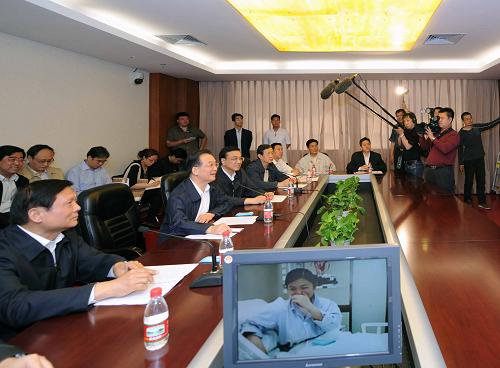 5月17日,中共中央政治局常委、国务院总理温家宝来到北京地坛医院,看望北京确诊的首例甲型H1N1流感患者和医护人员,并来到中国疾病预防控制中心考察甲型H1N1流感防控工作。中共中央政治局常委、国务院副总理李克强,中共中央政治局委员、北京市委书记刘淇,国务委员兼国务院秘书长马凯一同看望和考察。这是温家宝在北京地坛医院,通过视频和这位患者亲切交谈。新华社记者 饶爱民 摄