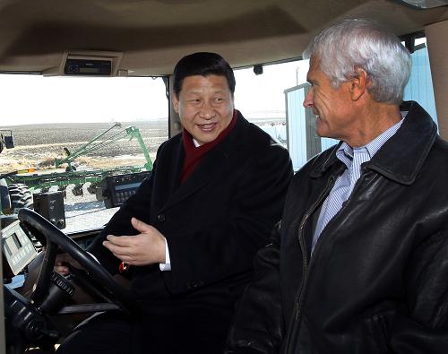 2月16日,中国国家副主席习近平在美国得梅因金伯利农场参观。这是习近平在农场主金伯利的陪同下操作其农用机械。 新华社记者 兰红光 摄