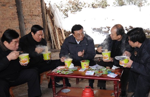 1月31日,李克强乘坐装有防滑链的汽车在崎岖覆冰的山路上行进3个小时,来到川北山区宣汉县老君乡紫云村。在察看灾情、慰问群众后,就和随行陪同的领导一起边用餐边研究救灾工作。饭后,又继续驱车到下一个村子慰问。 新华社记者 李学仁 摄