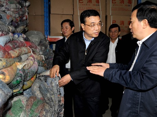 这是10月25日,李克强在成都救灾物资储备仓库,察看救灾募捐衣被的存储和发运情况。新华社记者 马占成 摄