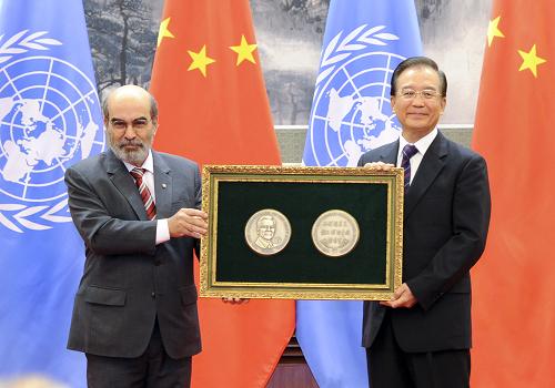10月2日,联合国粮食及农业组织在北京人民大会堂向国务院总理温家宝颁发“农民”奖章。这是联合国粮农组织总干事达席尔瓦向温家宝颁发镶嵌“农民”奖章的牌匾。新华社记者 谢环驰 摄