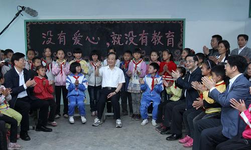 5月25日,在古丈县双溪乡中心完全小学音乐教室,温家宝与教师、留守儿童和家长座谈。新华社记者 庞兴雷 摄