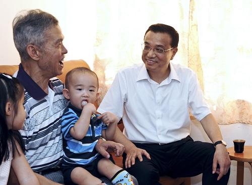 8月16日,中共中央政治局常委、国务院副总理李克强考察香港公屋屋村并看望家住九龙观塘平田村73岁的退休职工杨修举一家。 新华社记者 宋振平 摄