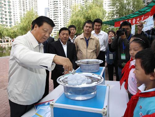2011年9月18日,时任中共中央政治局委员、中央书记处书记、中宣部部长的刘云山在北京同首都群众一起参加全国科普日北京主场活动。这是刘云山在朝阳区茉藜园社区与小学生们一起做节水小实验。新华社记者 刘卫兵 摄
