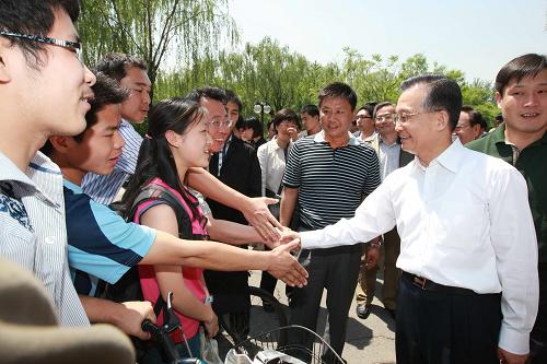 这是温家宝在校园里同学生们亲切握手。新华社记者 鞠鹏 摄