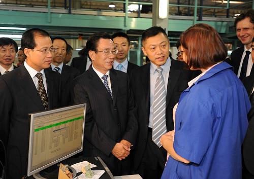 7月7日,正在波兰进行正式友好访问的中共中央政治局常委、中央纪委书记贺国强参观TCL波兰电视机生产厂。这是贺国强在生产车间内与工作人员亲切交谈。新华社记者 李涛 摄