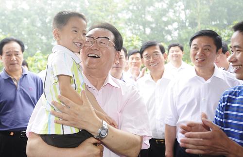 这是6月26日,李长春在成都市双流县兴隆镇瓦窑村农民刘彬家里了解其生产生活情况。 新华社记者 江宏景 摄