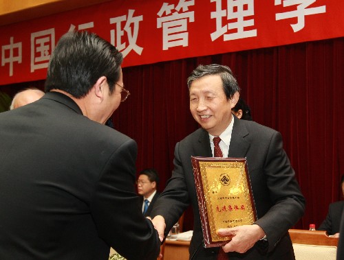 10月27日,马凯(右)为先进集体颁奖。 当日,中国行政管理学会第五次代表大会在北京召开,国务委员兼国务院秘书长马凯出席会议并讲话。新华社记者 庞兴雷 摄