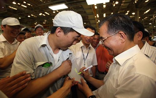 7月25日至27日,中共中央政治局常委、国务院总理温家宝到吉林考察。这是7月26日,温家宝在一汽轿车股份有限公司考察时应一位工人的要求,在他的工作服上签名留念。 新华社记者姚大伟摄