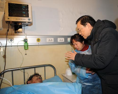 11月21日,根据胡锦涛总书记、温家宝总理的重要指示,中共中央政治局委员、国务院副总理张德江赶赴黑龙江龙煤集团鹤岗分公司新兴煤矿事故现场,指导救援工作。这是张德江在鹤岗市鹤矿集团总医院重症监护病房内看望受伤人员。新华社记者 李涛 摄
