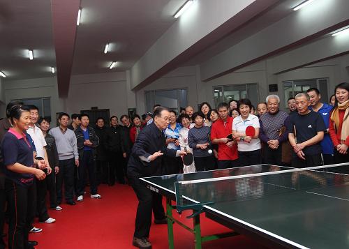 这是1月1日,温家宝在大庆市黎明社区,看望正在社区活动中心参加文体活动的居民并和他们一起打乒乓球。 新华社记者兰红光摄