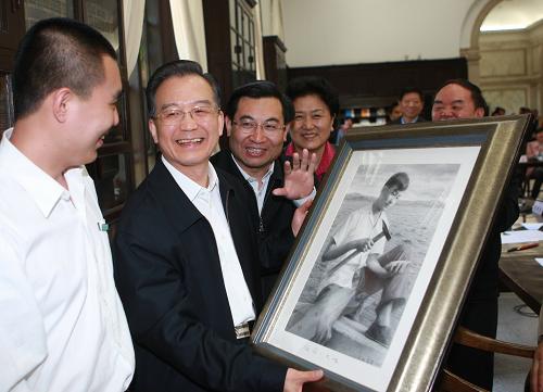这是一名清华大学美术学院的学生向温家宝赠送一幅名为《祖国·大地》的绘画作品。5月3日,中共中央政治局常委、国务院总理温家宝来到清华大学,与一批即将赴祖国西部和基层就业的清华大学应届毕业生代表座谈。 新华社记者 鞠鹏 摄