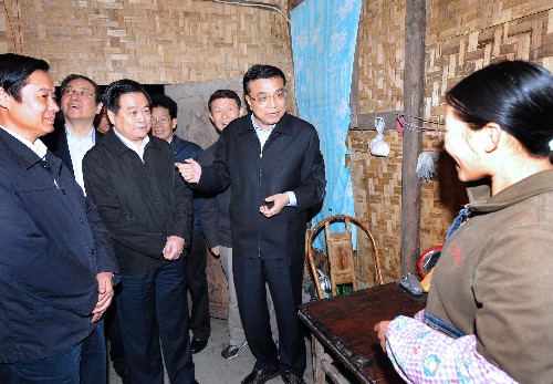 这是10月26日,李克强在漩口镇油辗村过渡性自建房里向村民汪娟了解生活情况。新华社记者 马占成 摄