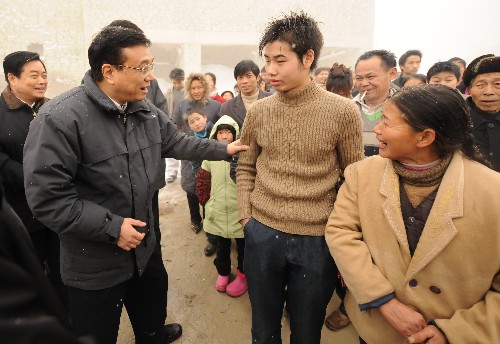 2月1日,李克强在邻水县城北镇罗解村察看灾情慰问群众后下山时,路遇在寒风中排队等车的20多位群众,得知他们已经等了很久,就让他们挤上了随行的汽车,带他们一起下山。 新华社记者 李学仁 摄