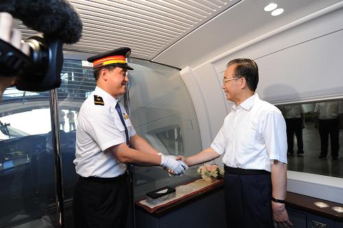 这是温家宝总理在发车前与京沪高铁首发列车驾驶员握手。 6月30日,京沪高速铁路全线建成通车,国务院总理温家宝出席通车运营仪式并乘首发列车考察运营情况。 新华社记者 王晔 摄