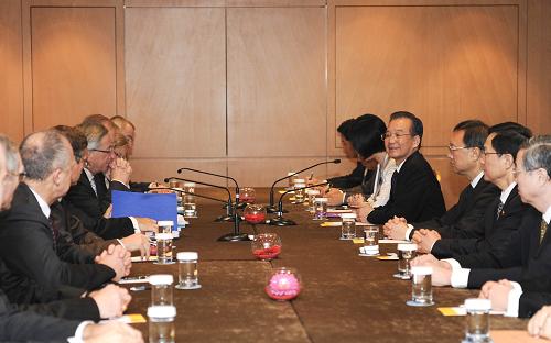 10月5日,中国国务院总理温家宝在布鲁塞尔会见欧元集团主席、卢森堡首相容克,欧洲央行行长特里谢,欧盟委员会负责经济和货币事务的委员雷恩。新华社记者 谢环驰 摄