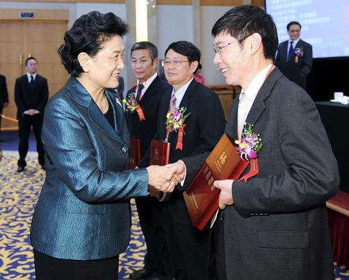 10月29日,中共中央政治局委员、国务委员刘延东在北京出席何梁何利基金2012年度颁奖大会并讲话。这是刘延东给获奖者颁奖。新华社记者 谢环驰 摄