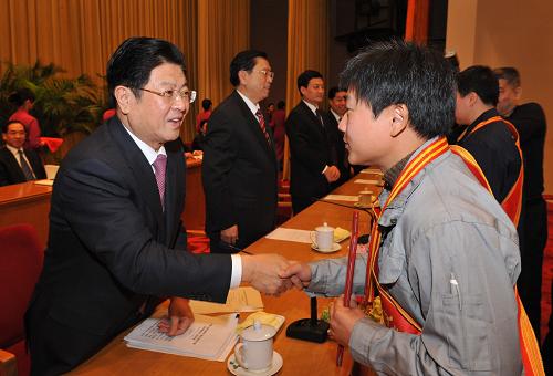12月8日,第三届全国职工职业技能大赛总结表彰大会在北京召开。中共中央政治局委员、全国人大常委会副委员长、中华全国总工会主席王兆国,中共中央政治局委员、国务院副总理张德江出席大会并会见获奖代表。这是王兆国(左一)为获奖代表颁发证书。新华社记者 何俊昌 摄