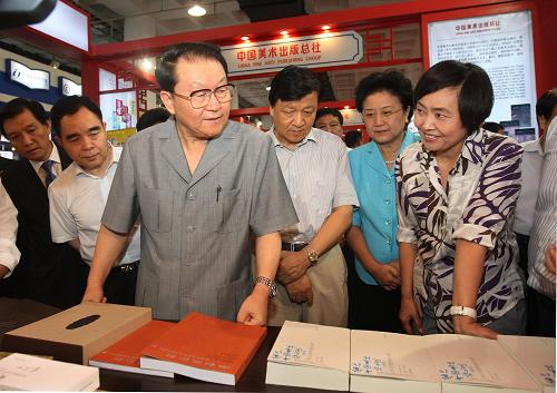 9月3日,中共中央政治局常委李长春在北京参观第十六届北京国际图书博览会。这是李长春在仔细观看博览会上展出的图书。 新华社记者 刘卫兵摄