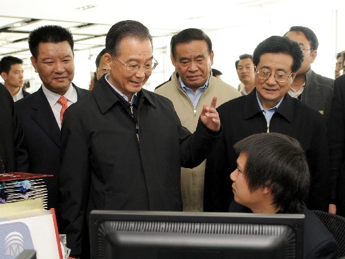 11月21日,温家宝总理在浙江梦娜袜业股份有限公司考察时与设计人员交谈。新华社记者 马占成 摄