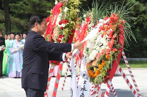 7月26日,国家副主席李源潮在朝鲜桧仓中国人民志愿军烈士陵园整理花圈缎带。 正在朝鲜访问并出席朝鲜战争停战60周年纪念活动的国家副主席李源潮当天在平壤参谒友谊塔,并前往桧仓中国人民志愿军烈士陵园,凭吊烈士。 新华社记者 张利 摄