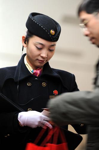 1月8日,长沙开往北京西的Z17列车女子乘务组乘务员为一名旅客服务。 新华社记者 赵众志 摄