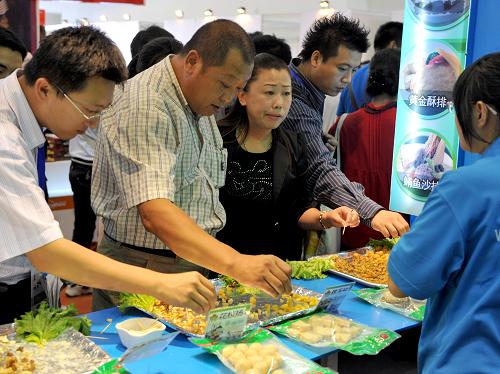 观众在东北亚博览会上品尝台湾展台上的食品(9月4日摄)。新华社记者 蒋林 摄