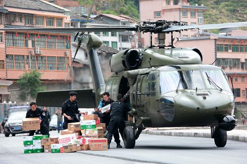 4月24日,成都军区第13集团军某陆航旅直升机把救灾物资运送到灾区宝兴县。 当日,成都军区第13集团军某陆航旅计划出动8批16架飞机,前往芦山、宝兴、太平、大川等地震重灾区运送急需生活用品,包括棉被、大衣、帐篷、水、方便面等急需生活用品。截至发稿时,这个陆航旅已运送12吨救灾物资到灾区各地。新华社记者 李刚 摄