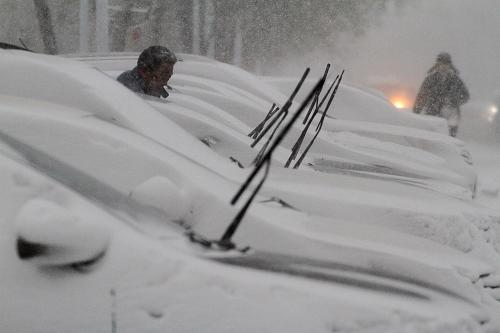 11月26日,在山东省烟台市芝罘岛东路,车辆被积雪覆盖。