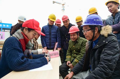 12月2日，志愿者在帮农民工买票。当日，合肥市黄山路社区开展“关爱农民工 情暖返乡路”订票活动，组织青年志愿者深入外来务工人员集中的建筑工地，帮助农民工在网上订票，方便他们及时买到春节返乡车票。新华社记者 杜宇 摄