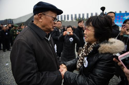 12月13日，南京大屠杀死难者国家公祭仪式现场，日本史学研究者松冈环（前右）和南京大屠杀幸存者向远松（前左）交谈。